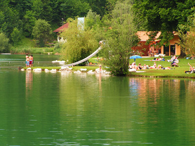 Das Freibad des Wössner Sees mit Rutsche Liegewiese und Seestüberl.